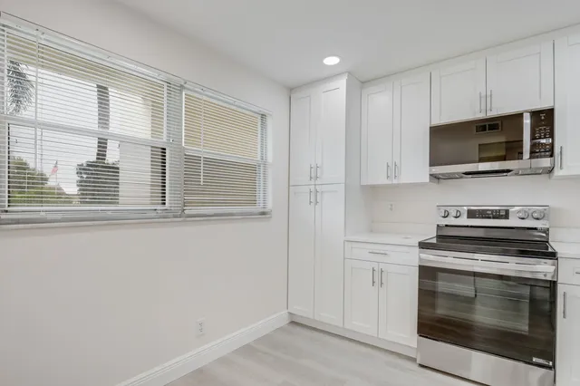 a kitchen with stainless steel appliances a stove microwave and sink