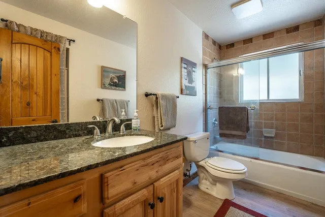 a bathroom with a granite countertop toilet sink and mirror