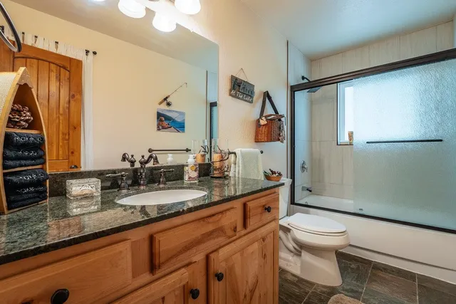 a bathroom with a granite countertop sink mirror vanity and toilet