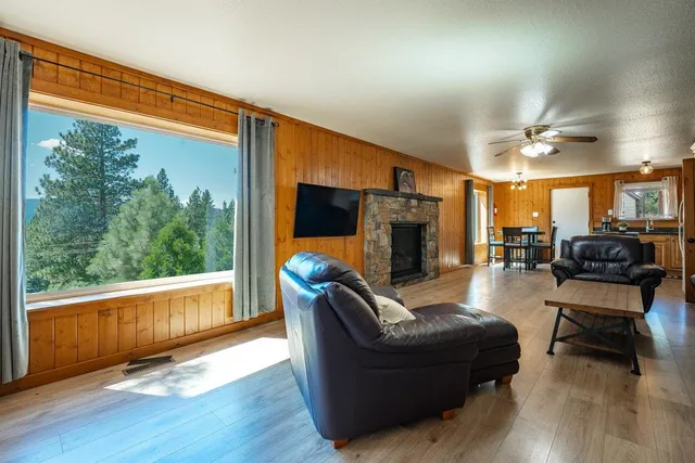 a living room with fireplace furniture and a large window