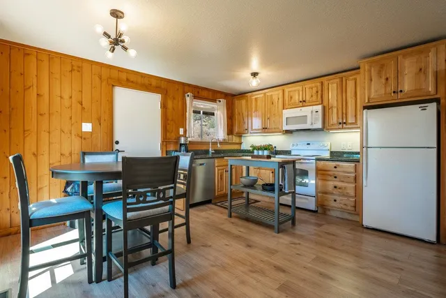 a kitchen with a table chairs refrigerator and cabinets