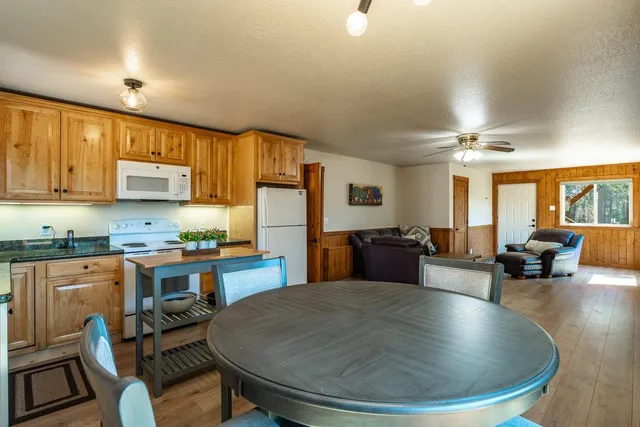 a kitchen with sink a refrigerator and chairs