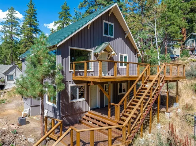 a view of a house with wooden deck front of house