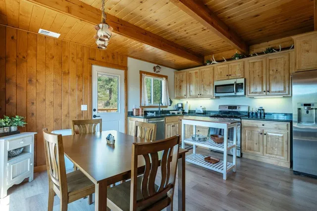 a kitchen with granite countertop a table chairs microwave and cabinets
