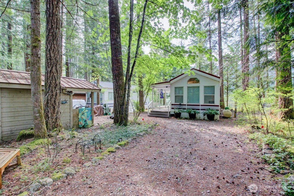 a view of a house with a yard and large trees