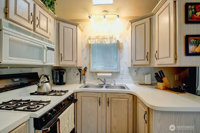 a kitchen with stainless steel appliances a stove a sink and cabinets