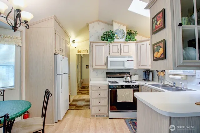 a kitchen with stainless steel appliances a stove a sink and a refrigerator