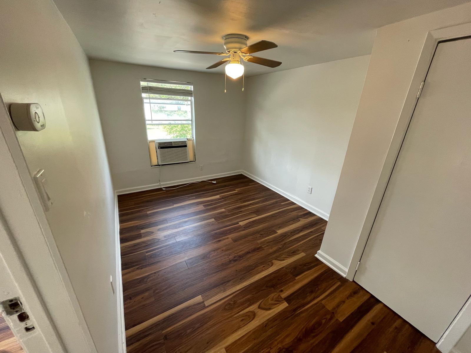 6404 Ponca Street, Unit B Austin, TX 78741 - Photo 8 of 17 a view of an empty room with window and wooden floor