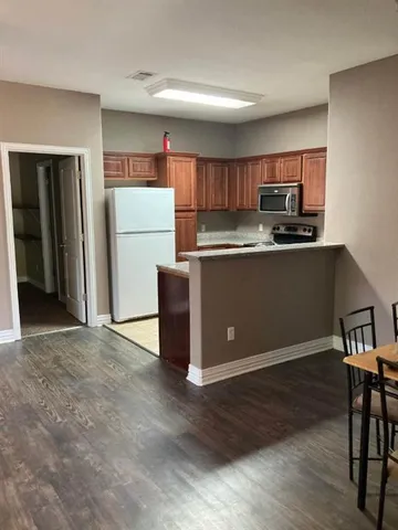 a kitchen with stainless steel appliances granite countertop a refrigerator and a stove top oven
