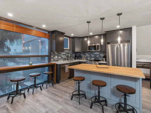 a kitchen with a table chairs refrigerator and microwave