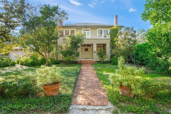 a front view of a house with a yard and trees