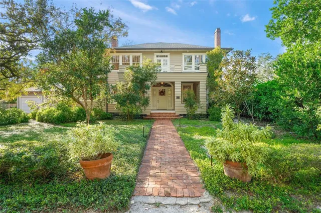 a front view of a house with a yard and trees
