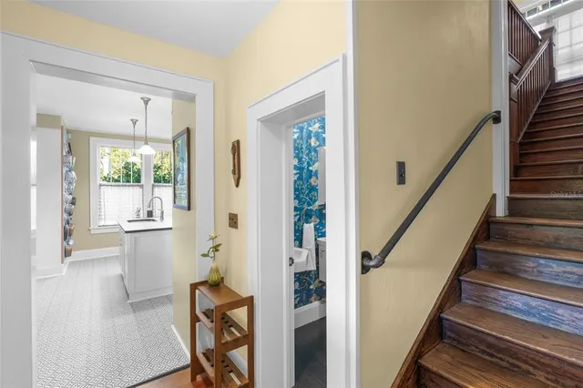 a view of a hallway with wooden floor and stairs