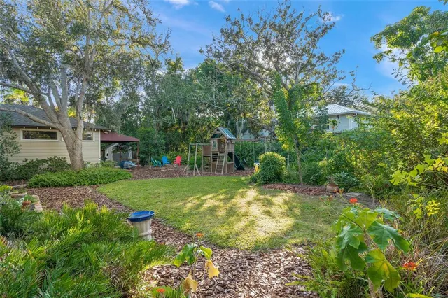 a view of a yard with plants and trees