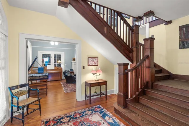a living room with wooden floor and a dining table