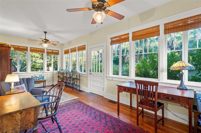 a dining room with furniture large windows and wooden floor