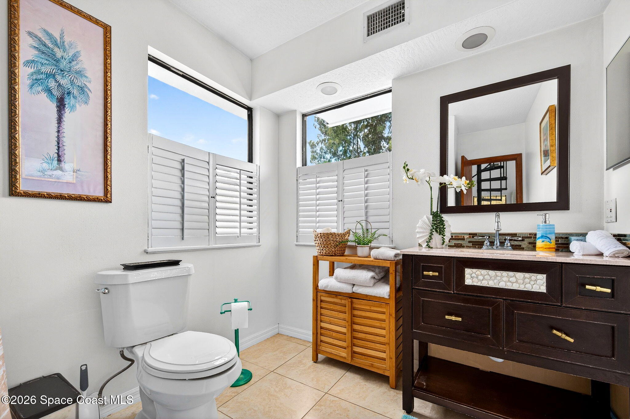 51 Vip Island, Unit B Grant, FL 32949 - Photo 21 of 49 a bathroom with a toilet a sink a vanity and mirror