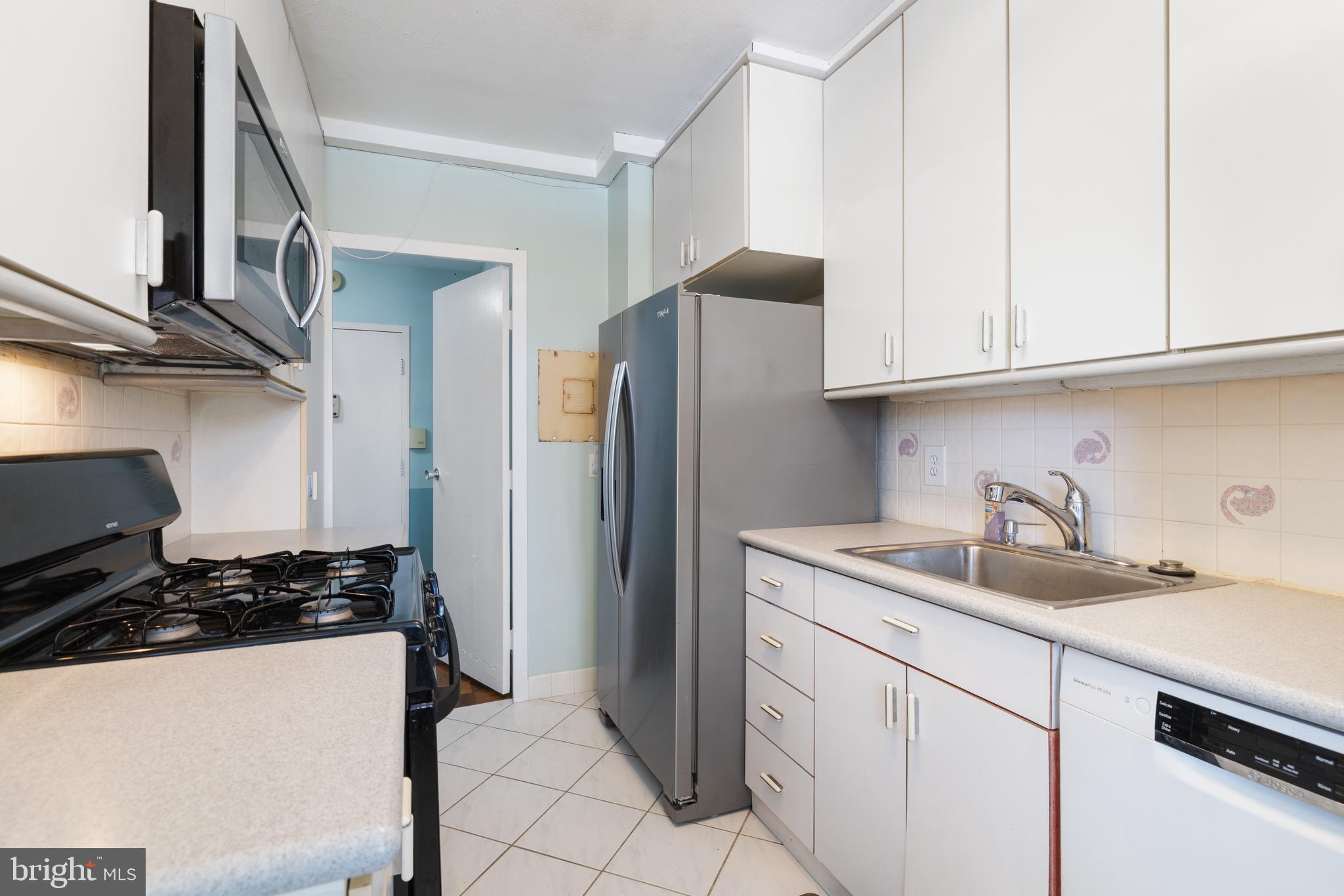 7900 Old York Road, Unit 303B Elkins Park, PA 19027 - Photo 10 of 27 a kitchen with a sink and a refrigerator