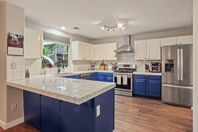 a kitchen with stainless steel appliances granite countertop a stove a sink dishwasher and a refrigerator