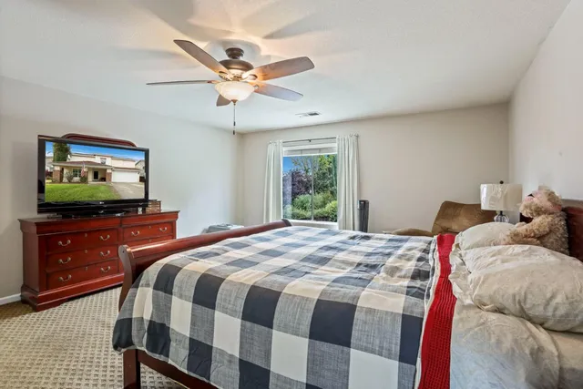 a spacious bedroom with a bed and a flat screen tv
