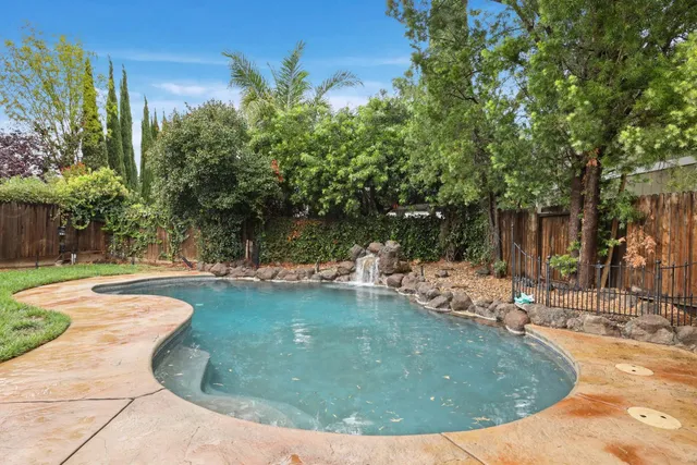 a view of a house with swimming pool and a yard