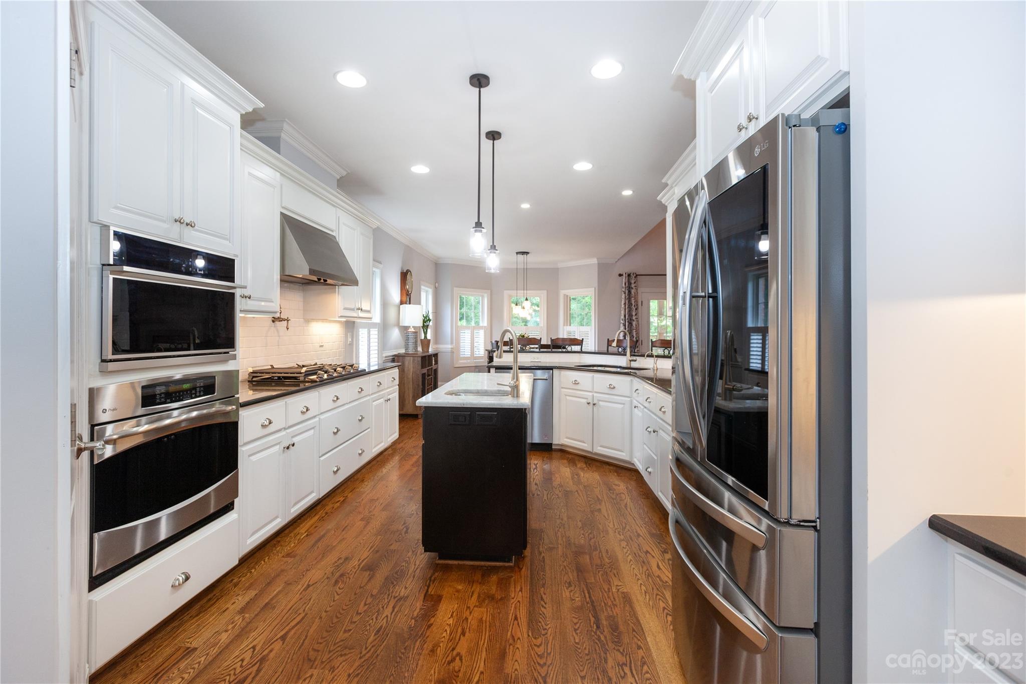 4058 Halyard Drive Denver, NC 28037 - Photo 11 of 46 a kitchen with stainless steel appliances granite countertop a refrigerator a stove top oven a sink dishwasher and wooden floor