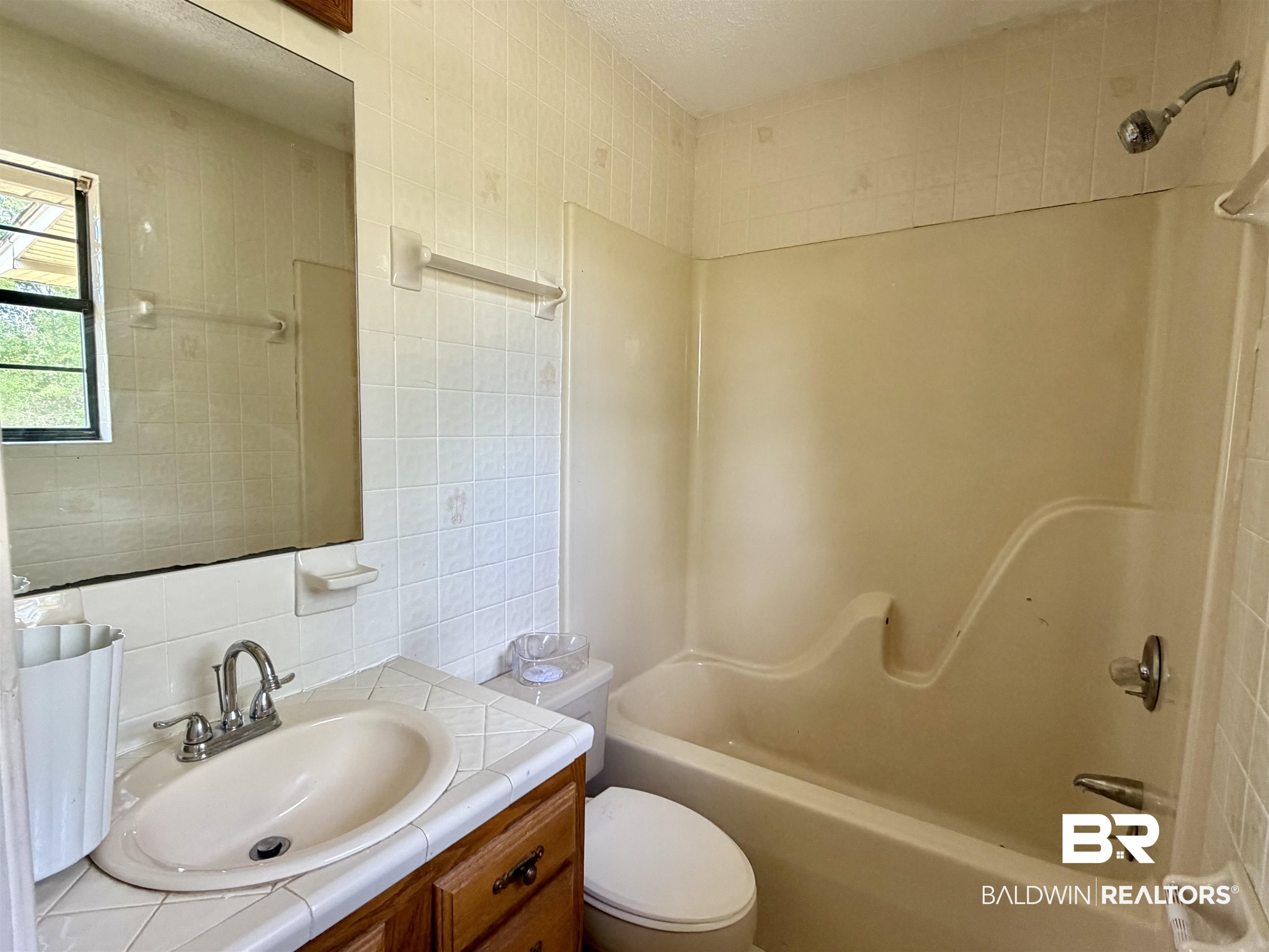 294 Wolf Log Road Flomaton, AL 36441 - Photo 9 of 14 Bathroom with tile walls, vanity, and bathtub / shower combination