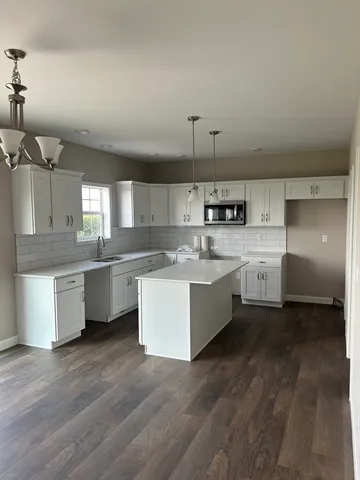 a large kitchen with kitchen island a sink stainless steel appliances and cabinets