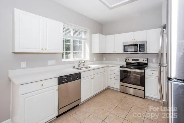 a kitchen with granite countertop white cabinets and white appliances