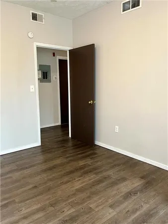 an empty room with wooden floor and closet