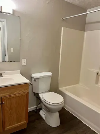 a white toilet sitting next to a bath tub