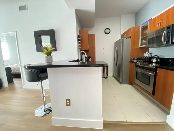 a kitchen with stainless steel appliances granite countertop a refrigerator and a stove top oven