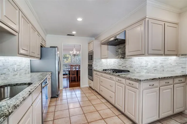 a kitchen with granite countertop a stove sink and cabinets