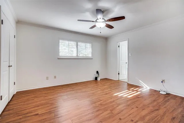 an empty room with wooden floor and chandelier fan