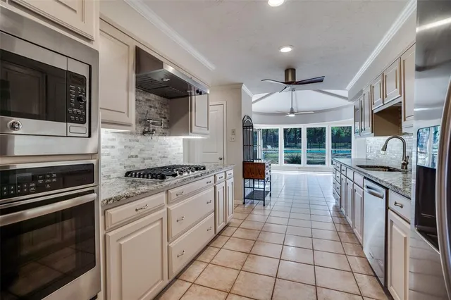 a kitchen with stainless steel appliances granite countertop a stove a sink and a microwave