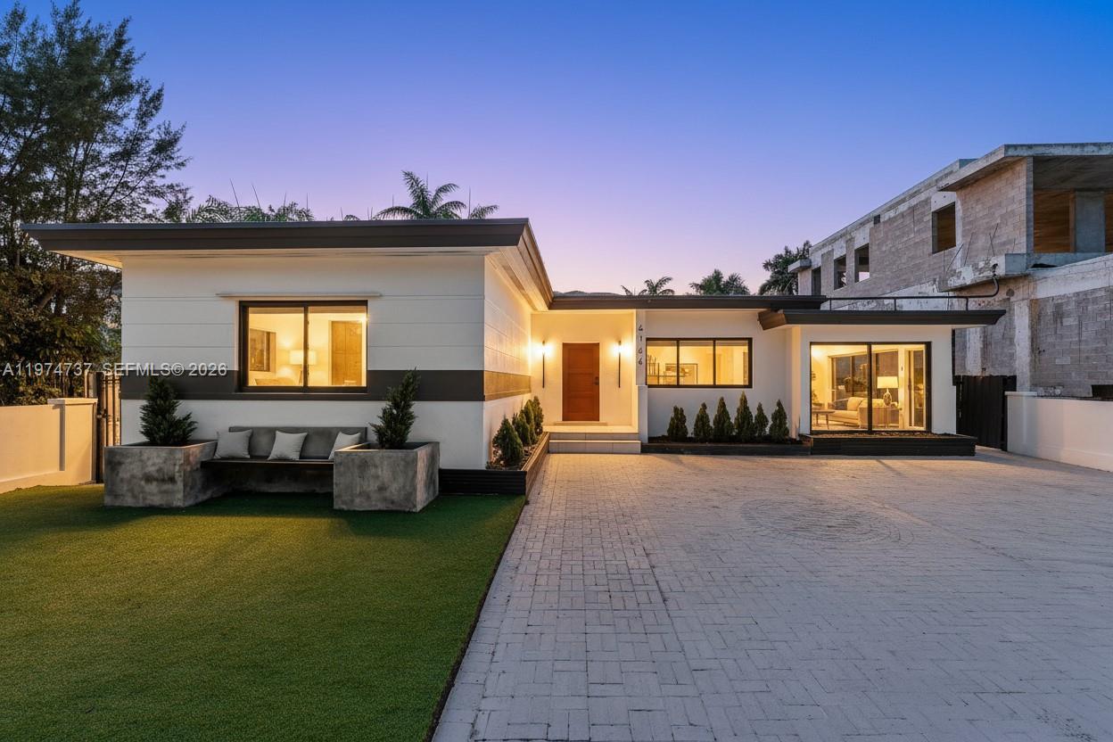 a view of a house with couches yard and a floor to ceiling window