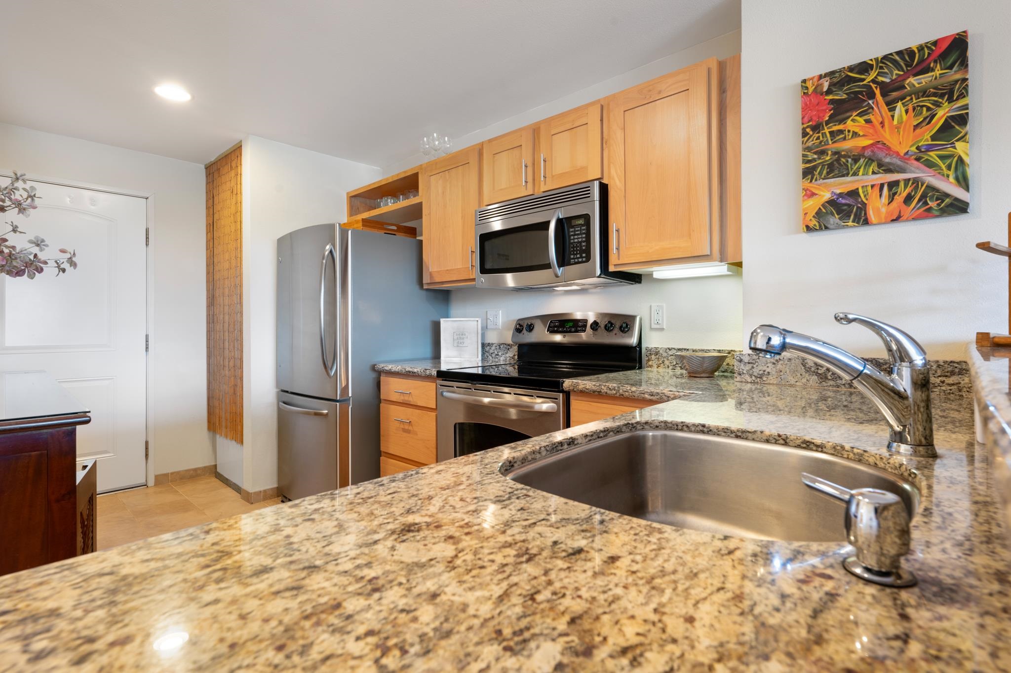 3708 Lower Honoapiilani Road, Unit E41 Lahaina, HI 96761 - Photo 14 of 42 a kitchen with stainless steel appliances granite countertop a sink refrigerator and microwave