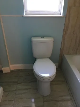 a bathroom with a granite countertop toilet sink and mirror