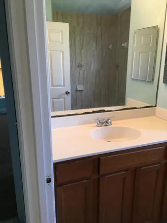 a bathroom with a sink a toilet and a mirror