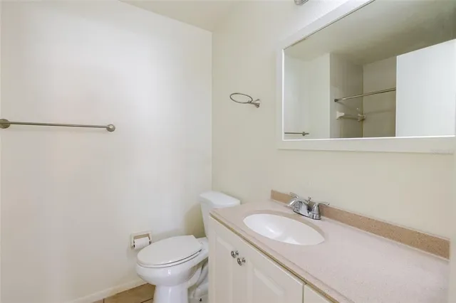 a bathroom with a granite countertop toilet and a sink