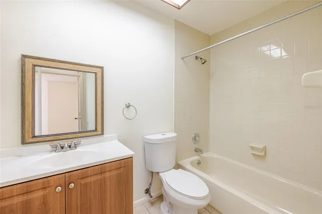 a bathroom with a granite countertop sink a toilet and shower
