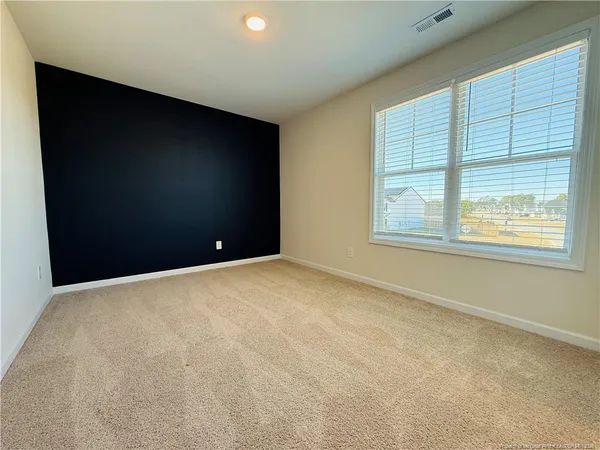 an empty room with windows and entrance to other room