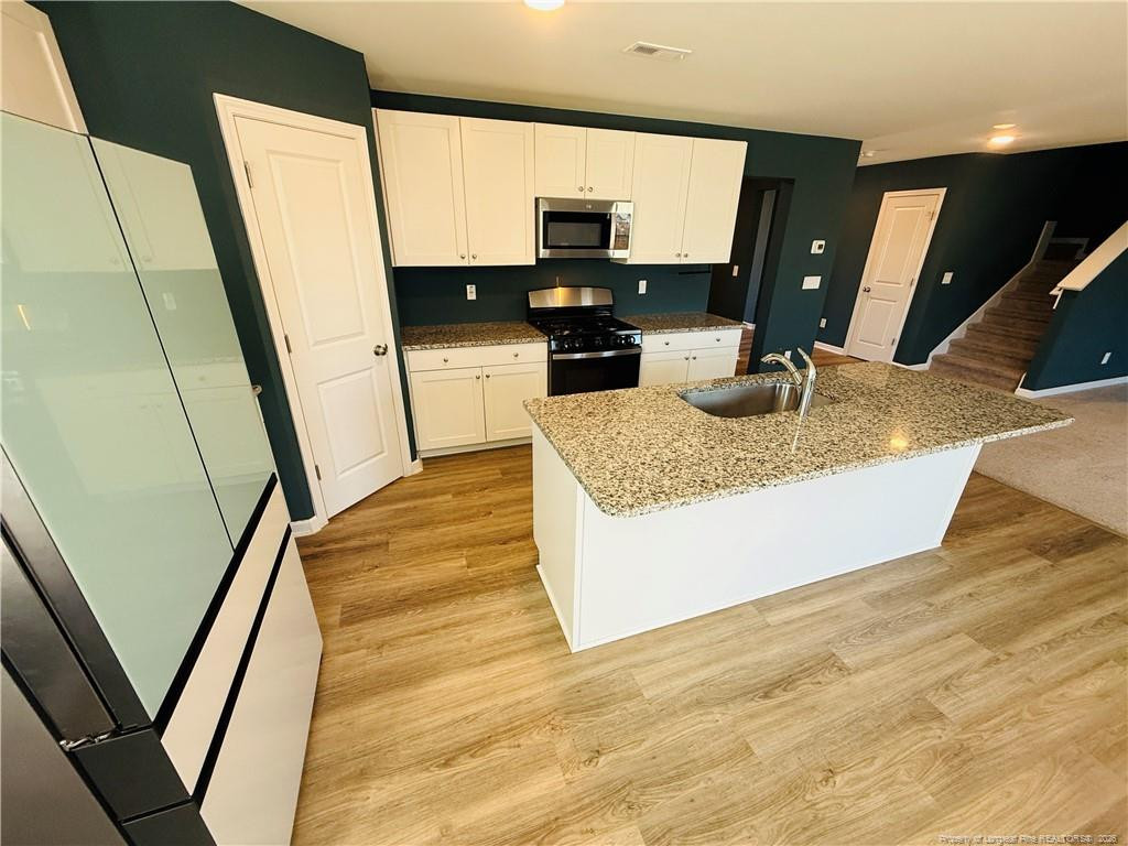4029 Racking Horse Road Hope Mills, NC 28306 - Photo 10 of 30 a kitchen with stainless steel appliances granite countertop a sink stove and refrigerator