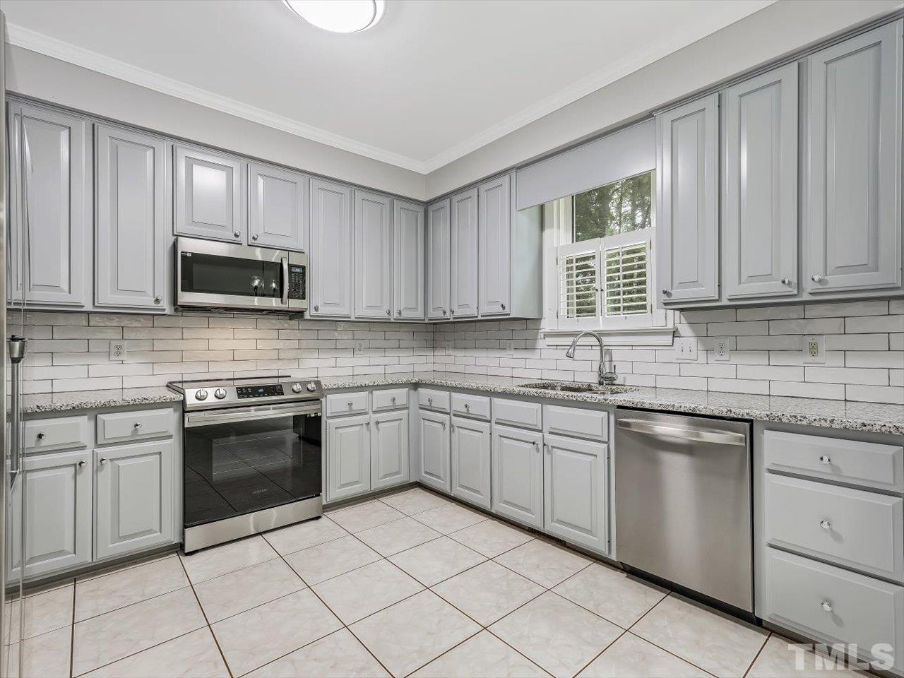 4 Caspian Court Durham, NC 27713 - Photo 18 of 84 a kitchen with granite countertop white cabinets sink and stainless steel appliances