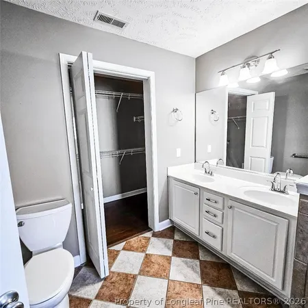 a bathroom with a double vanity sink toilet and mirror