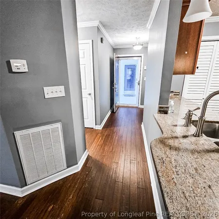 a view of a bedroom from hallway with wooden floor