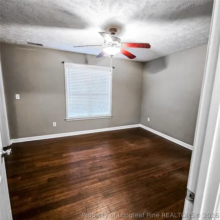 a view of a room with wooden floor and fan