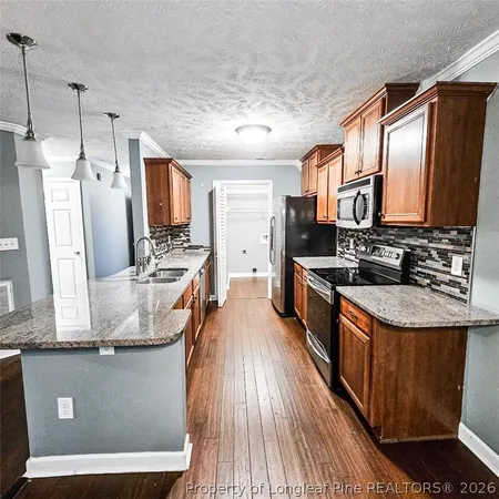 a large kitchen with stainless steel appliances granite countertop a stove a sink dishwasher and a refrigerator