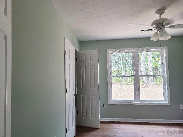 2711 Stonewall Road Concord, VA 24538 - Photo 10 of 14 an empty room with wooden floor fan and windows