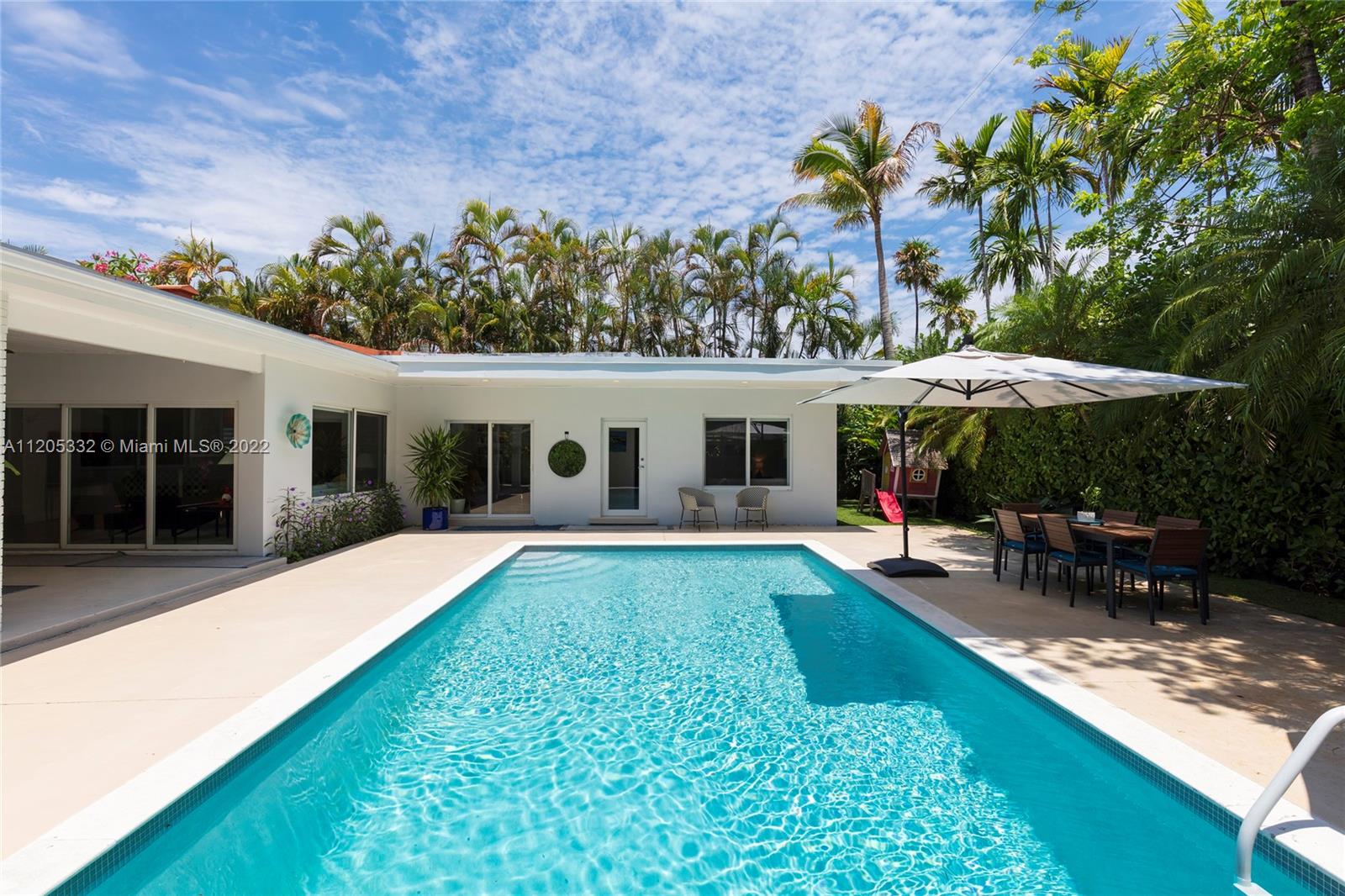 a view of a house with backyard sitting area and garden